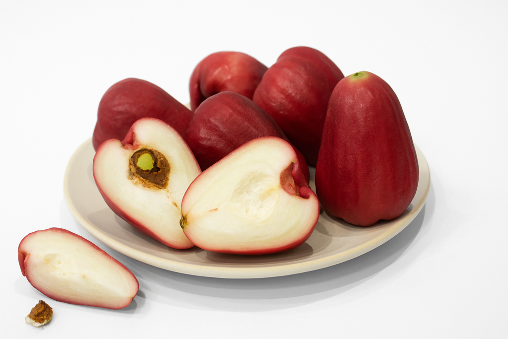 varias frutas jambo em prato e algumas cortadas ao meio