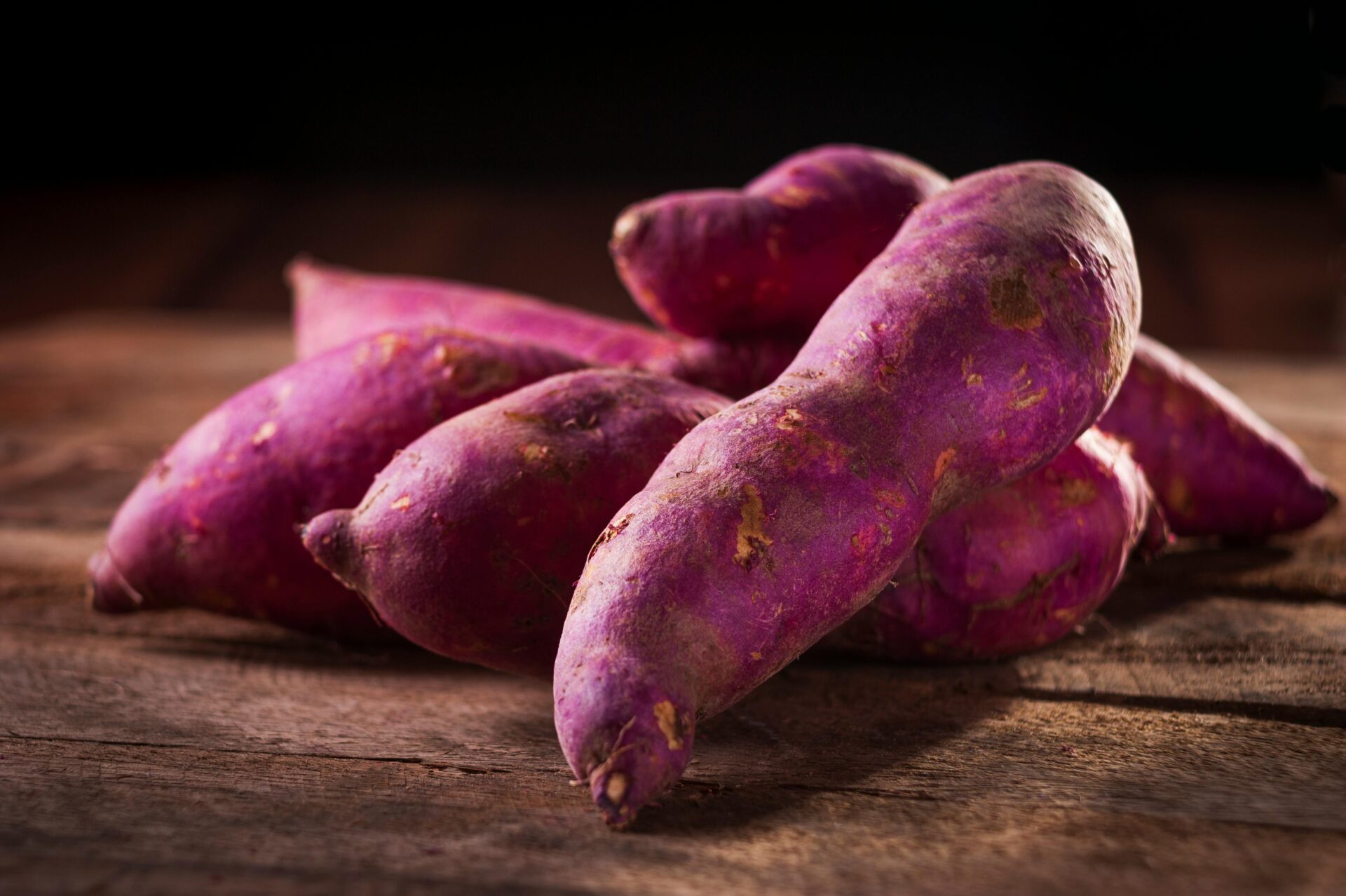 varias batatas-doces em cima de uma tábua