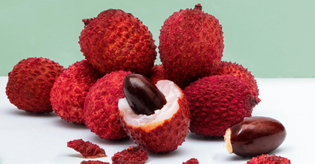 vários frutos de  lichia (Litchi chinensis), sendo um deles cortado ao meio com o caroço exposto
